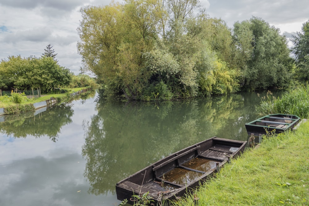 a row boat sitting on the side of a river