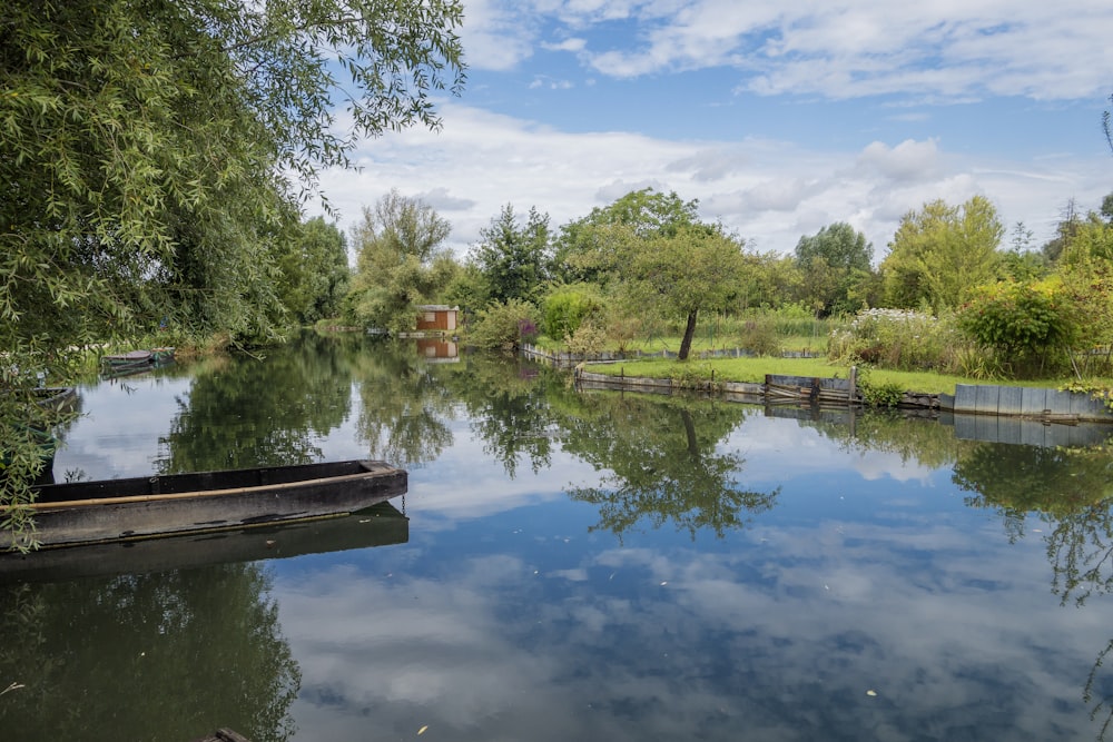 a boat floating on top of a river next to a lush green forest