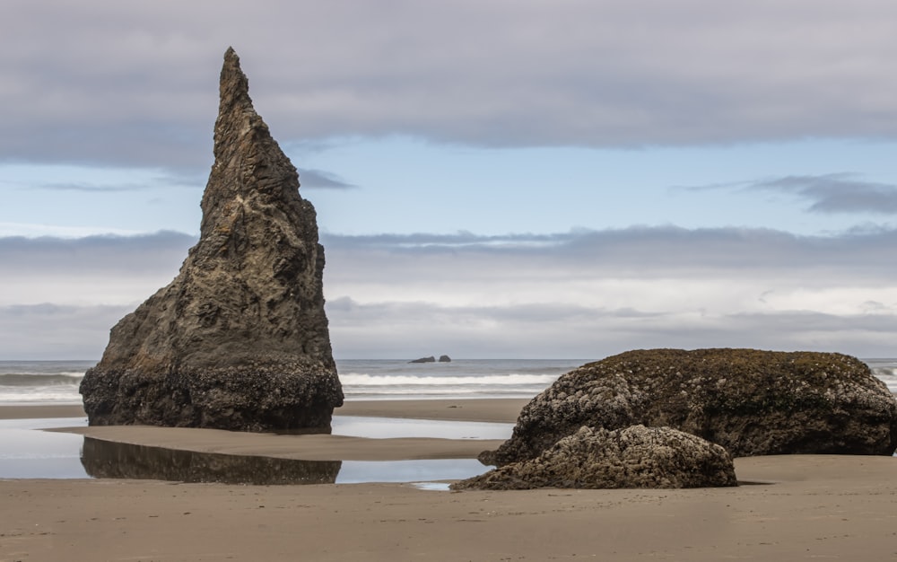 a large rock sitting on top of a sandy beach