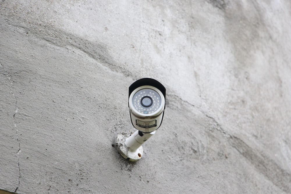 uma câmera de segurança montada na lateral de um prédio;