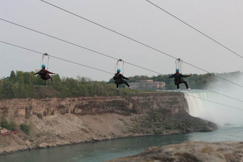 Group of friends crossing the zipline over the river at Parques Vale Beach.