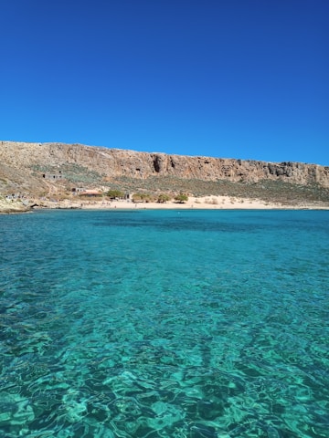A scenic view of a turquoise beach with clear blue skies inviting for adventure.
