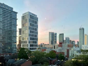 A cityscape with government buildings under a clear sky at sunset.