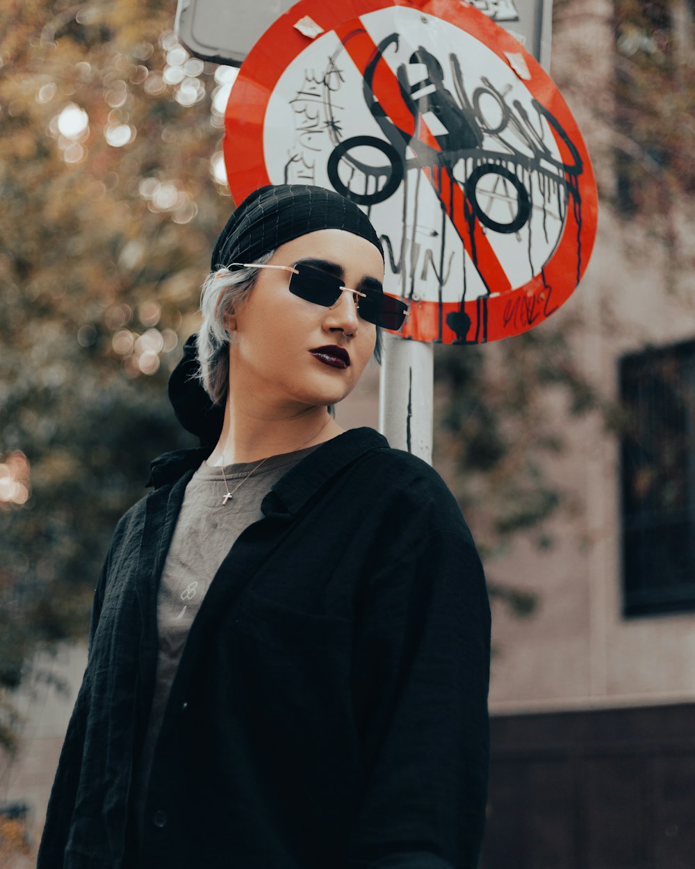 a woman standing next to a street sign