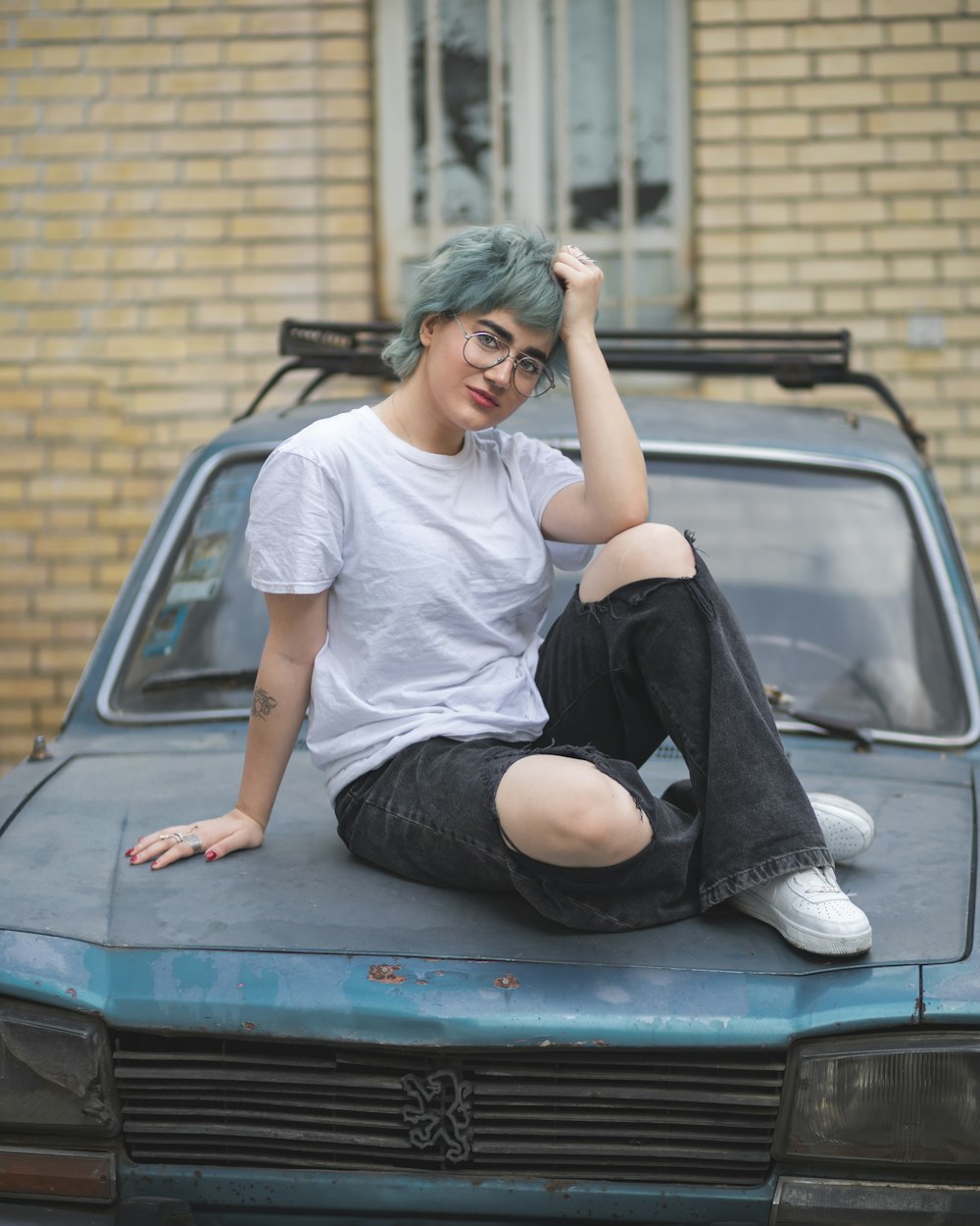 a person sitting on the hood of a car