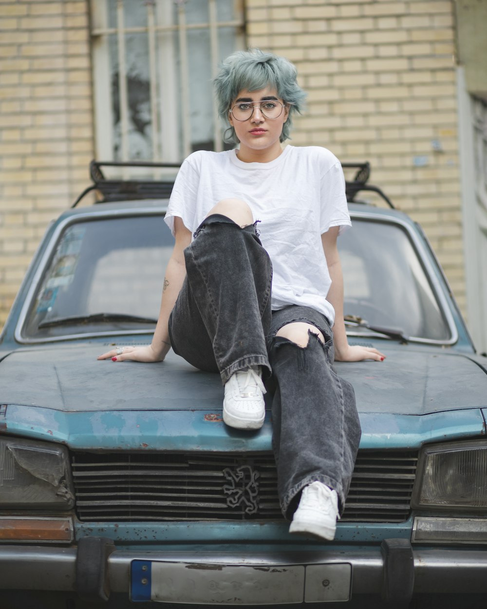 a person sitting on the hood of a car