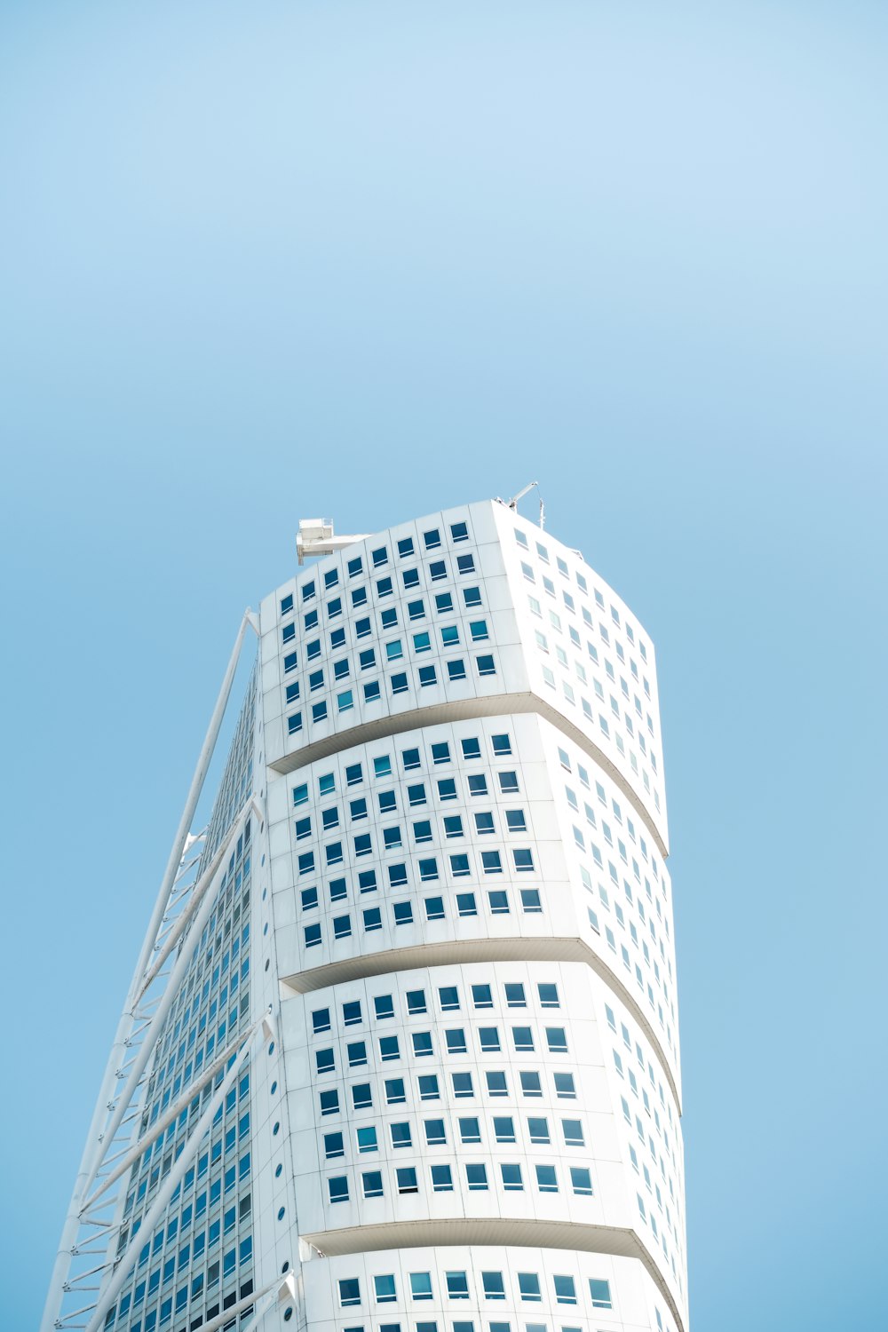 a tall white building with a blue sky in the background
