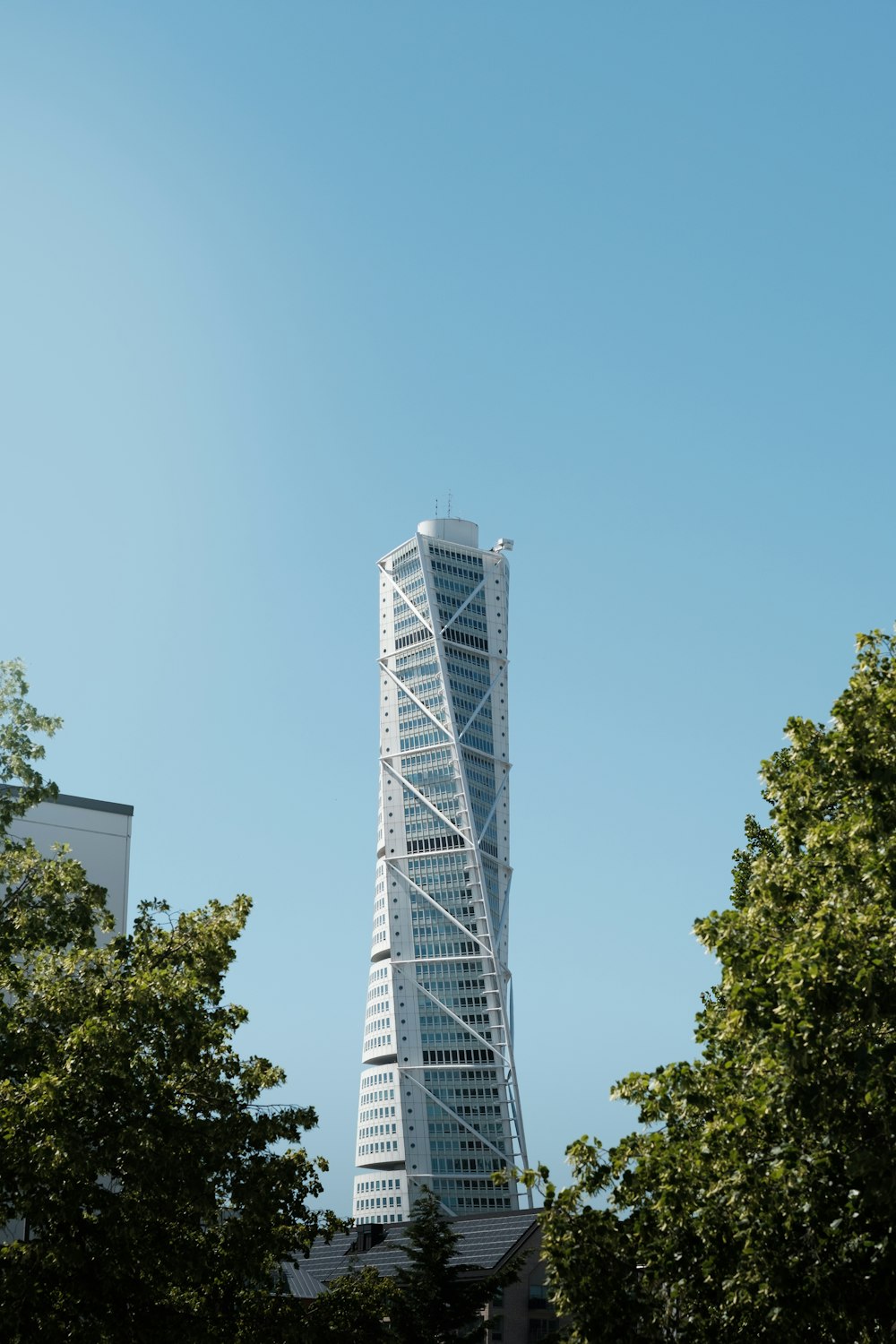 a very tall building surrounded by trees on a sunny day