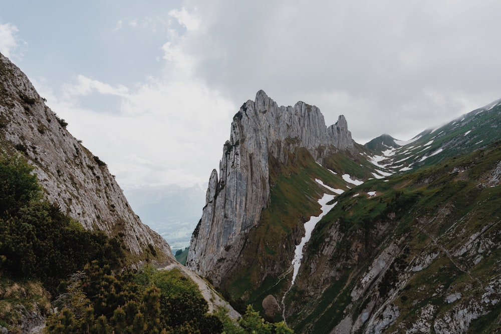 a view of a rocky mountain with snow on the top