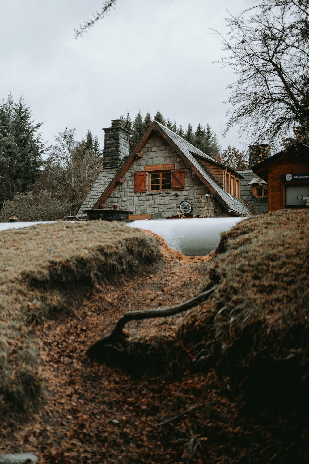 a house in the middle of a field with snow on the ground