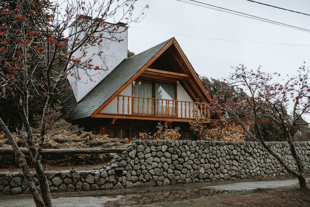 a house with a stone wall and a stone fence in front of it