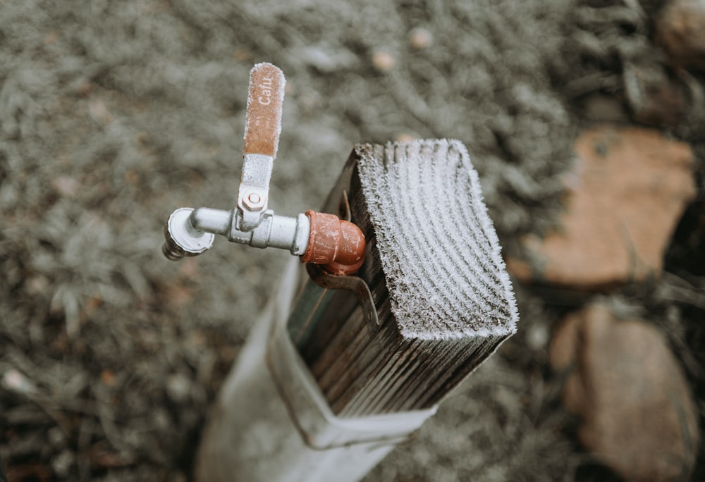 a close up of a metal pipe with a rusted handle