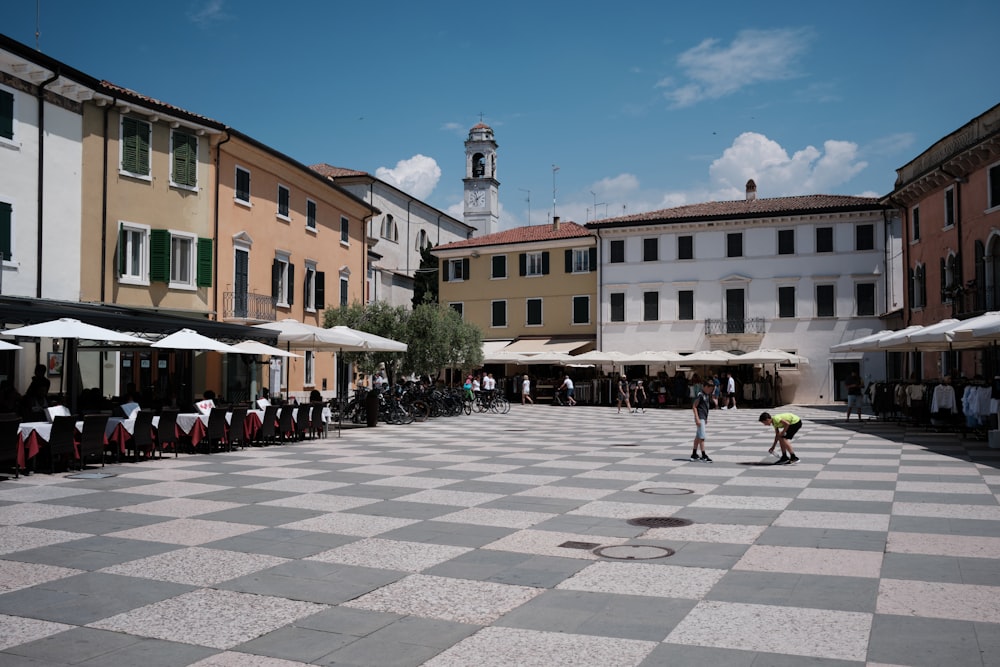 a group of people sitting at tables in a courtyard