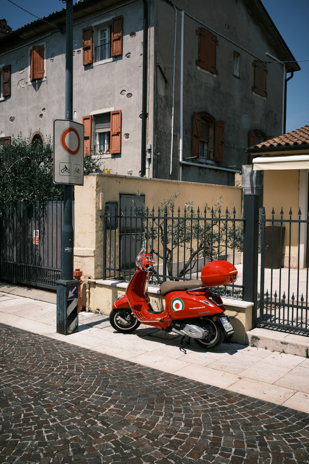 a red motorcycle parked in front of a building