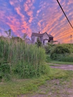 Sunset view over a farmhouse with rustic charm and natural surroundings.