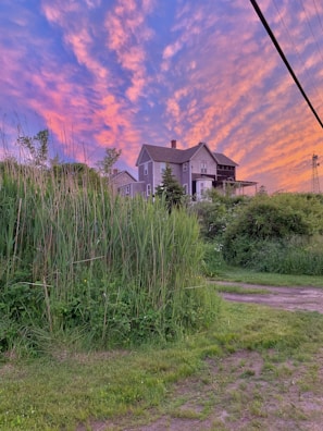 Sunset view over a farmhouse with rustic charm and natural surroundings.