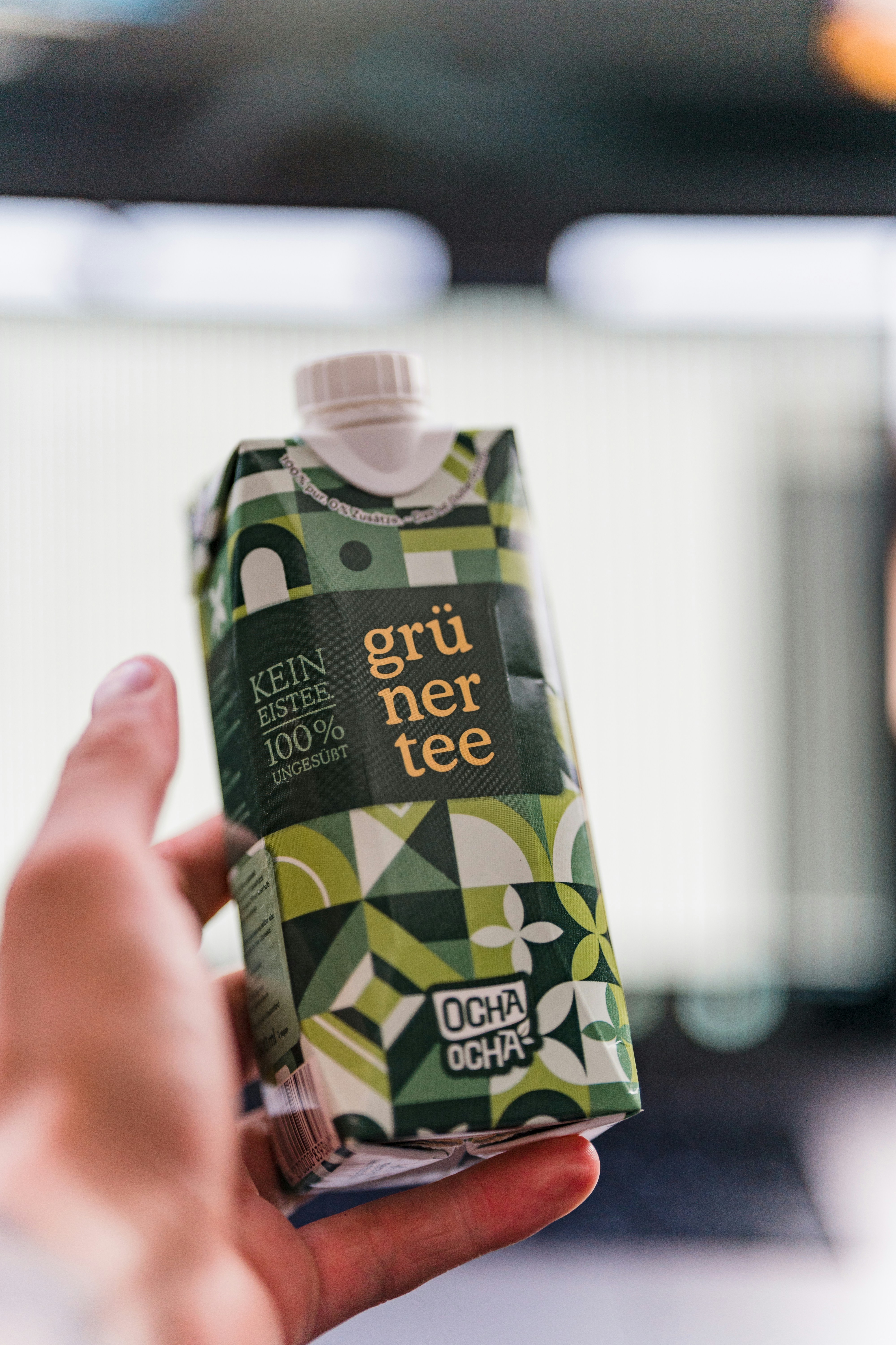 a person holding a can of green tea