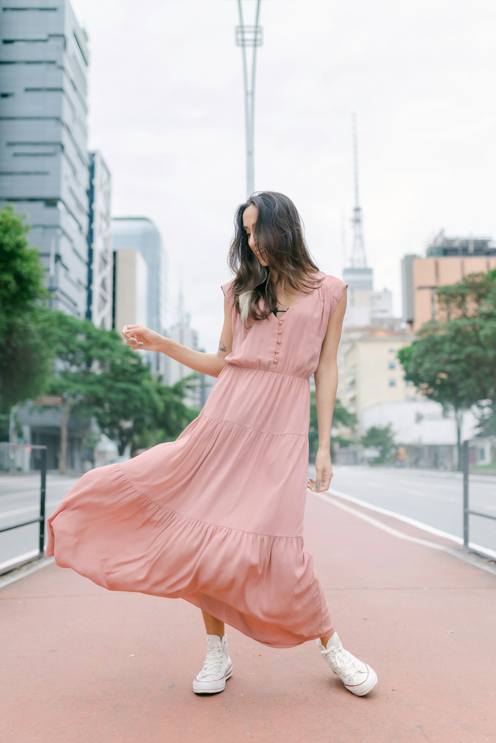 a woman in a pink dress is walking down the street