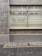 A brick wall with a window that has horizontal blinds partially closed. The word 'acme' is displayed in gold lettering on the glass. The facade includes a lower brick section and a pavement with a textured grid pattern adjacent to it.