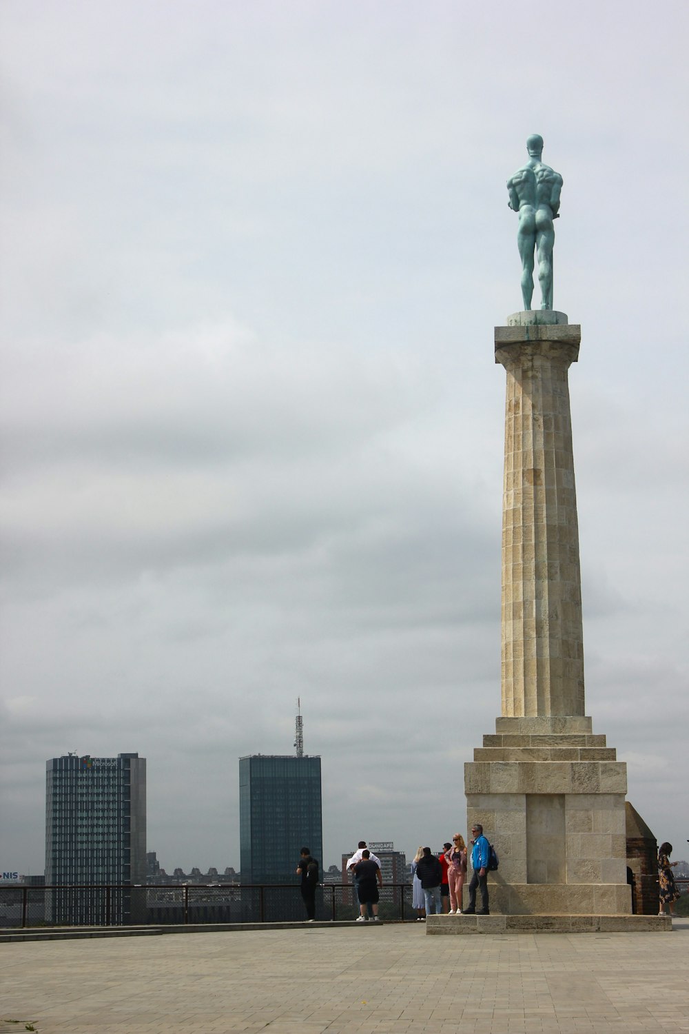 um grupo de pessoas em pé ao redor de uma estátua