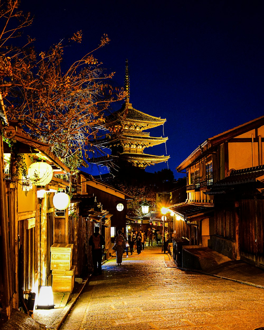 a narrow street with a pagoda in the background