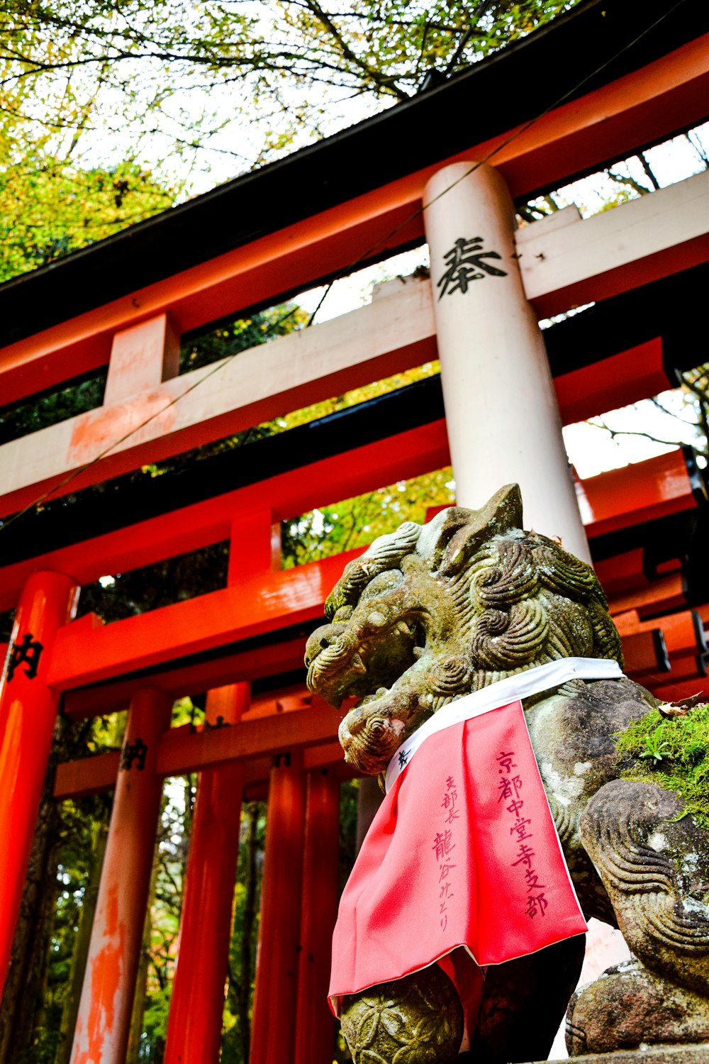 a statue of a lion in front of a red gate