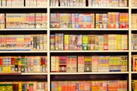 A collection of rare manga volumes stacked neatly on a dark graphite bookshelf.
