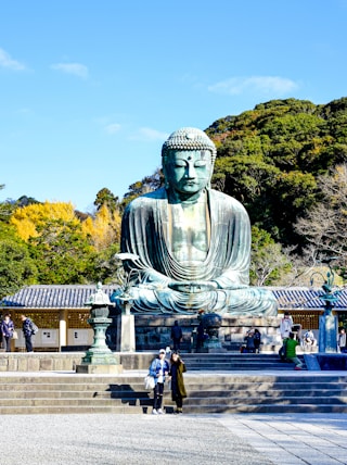 a large buddha statue sitting in the middle of a park