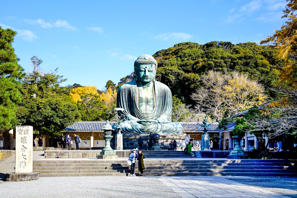 a large buddha statue sitting in the middle of a park