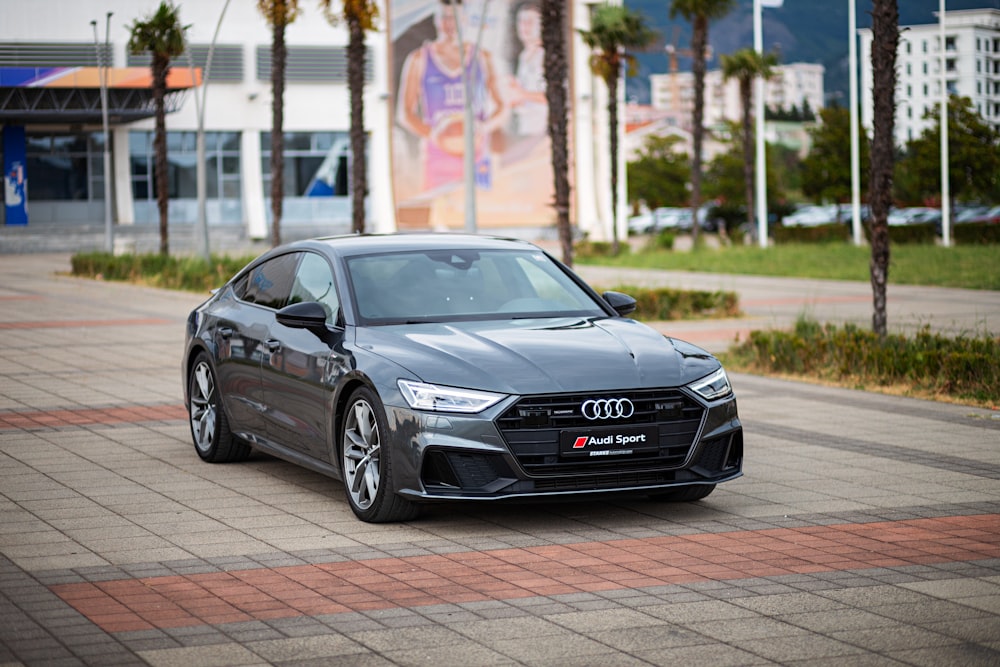 a grey car parked in front of a building