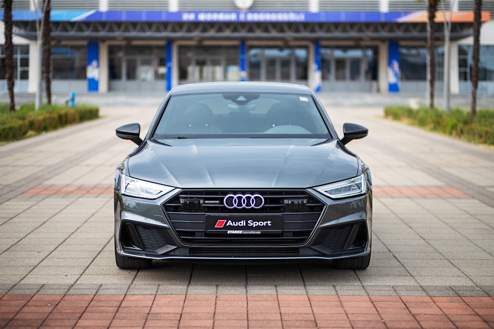 a grey car parked in front of a building