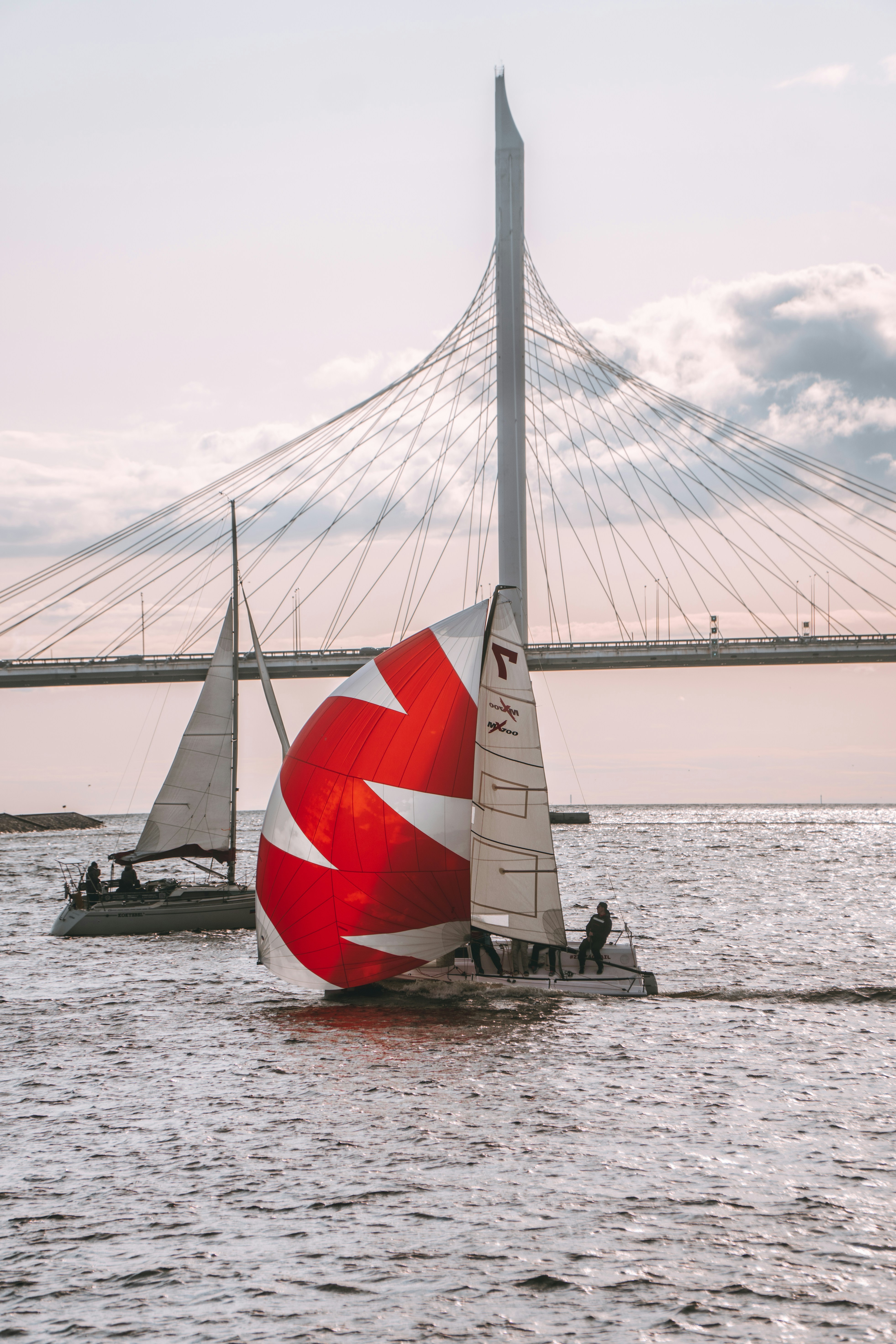 Un voilier avec une voile rouge et blanche sur un plan d’eau photo ...