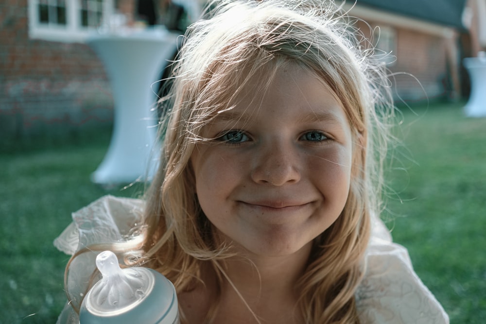 a little girl holding a bottle of milk