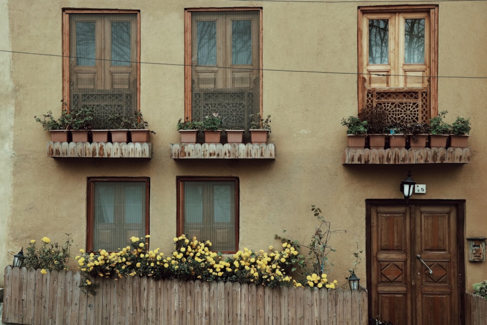 un bâtiment avec une clôture en bois et des bacs à fleurs aux fenêtres
