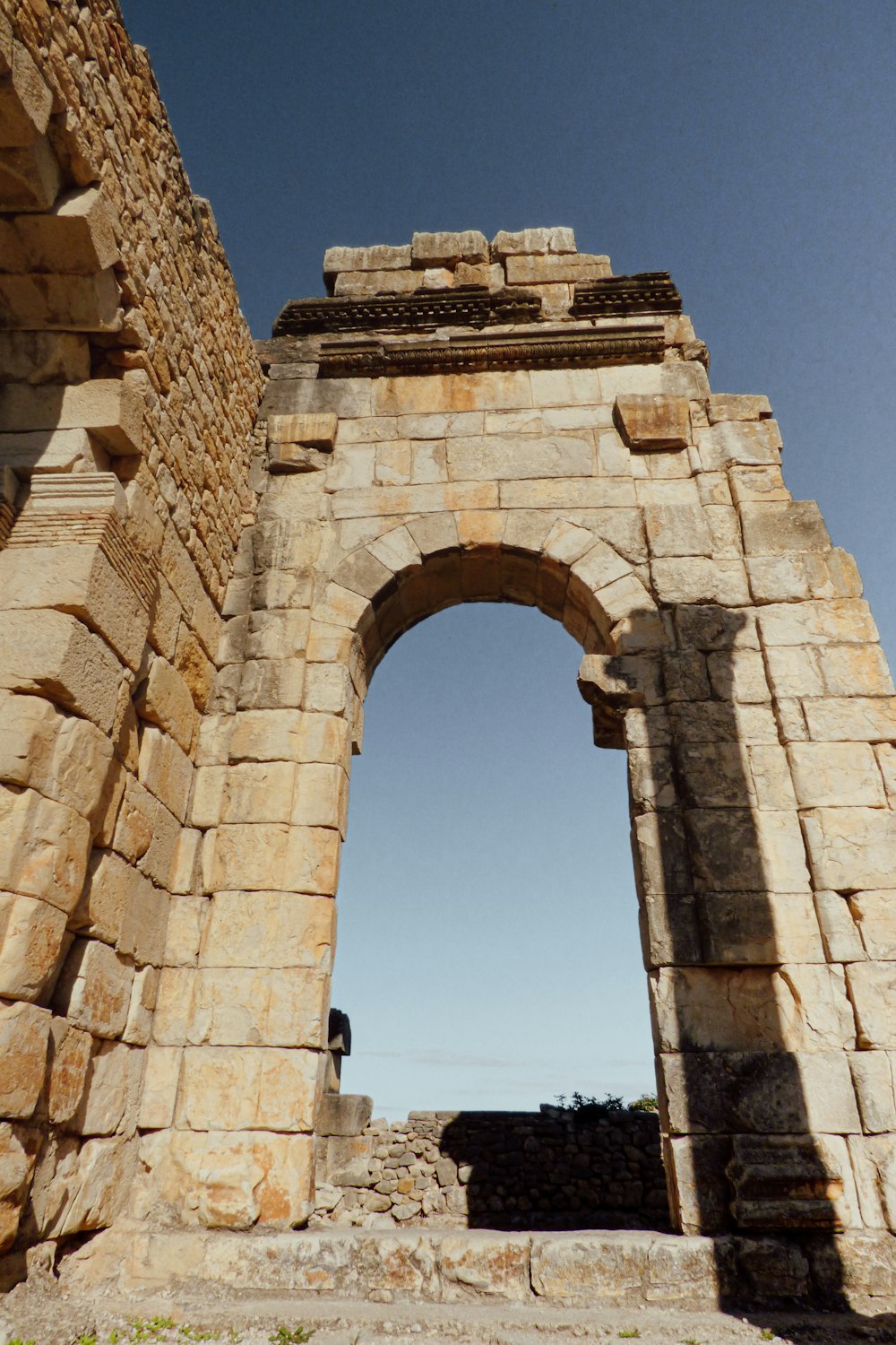 a stone arch with a clock on the top of it