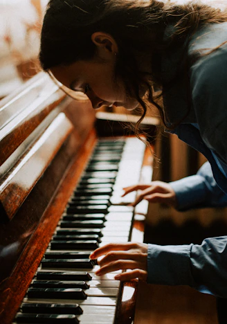 a woman playing a piano in a room