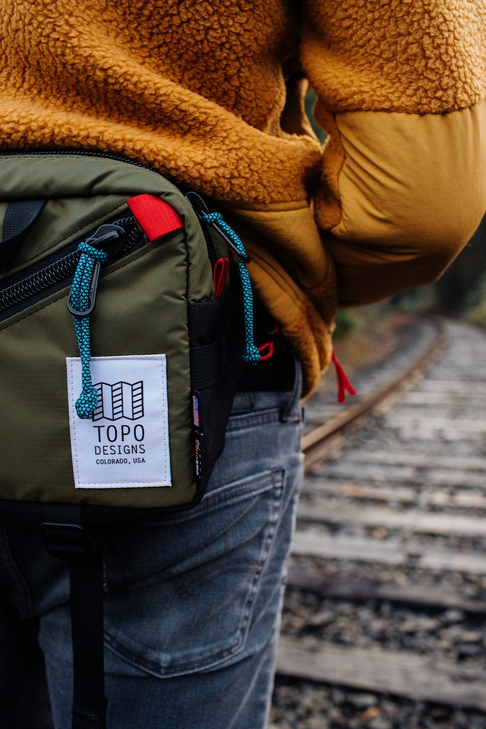 a person standing on a train track with a back pack