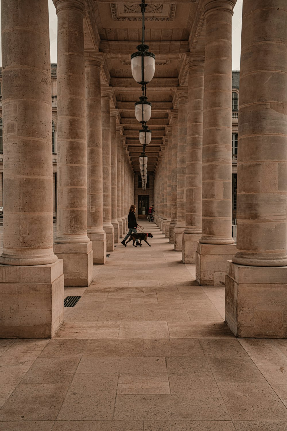 a person sitting on a bench under a covered walkway