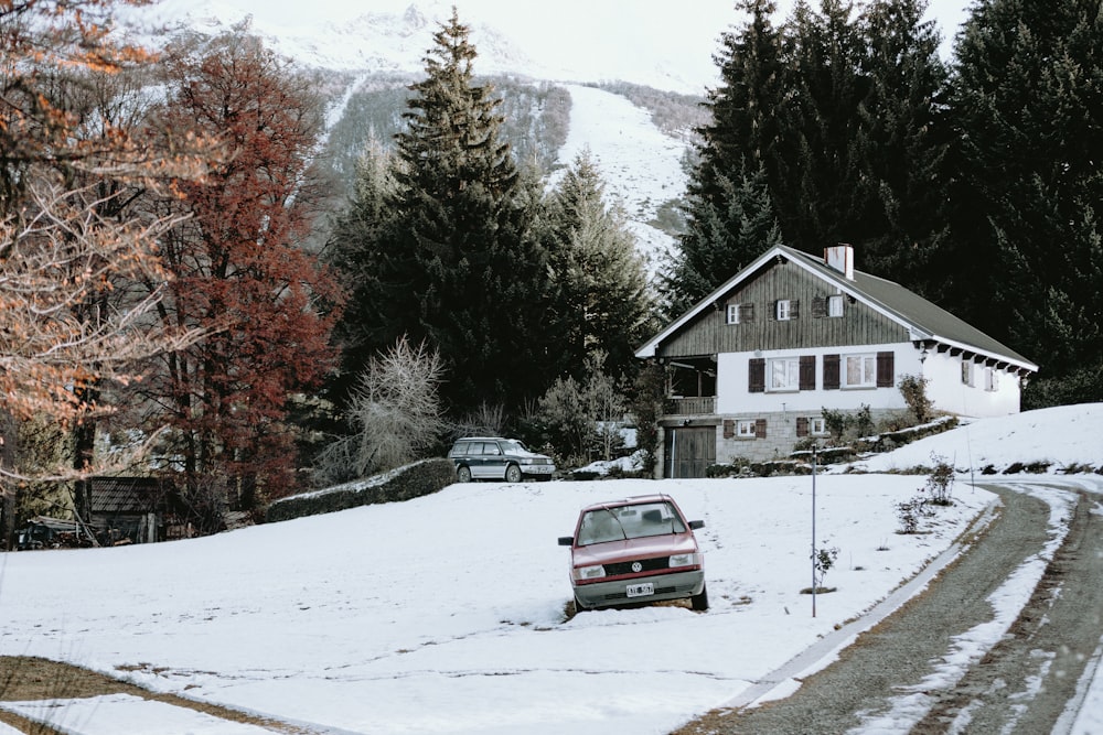 a car parked on a snowy road in front of a house