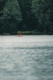 An instructor helping a beginner kayak smoothly through gentle tidal waters.