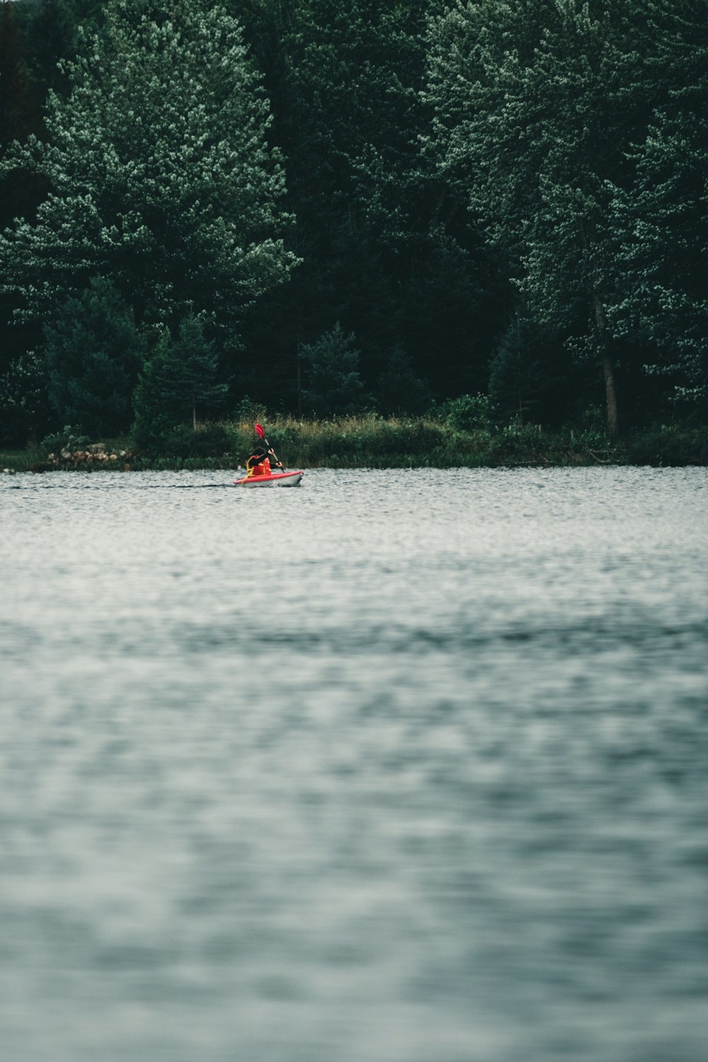 a person in a red boat on a body of water