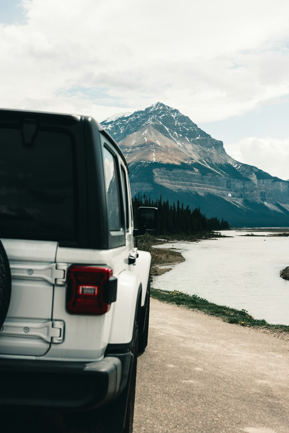 a white jeep parked on the side of a road