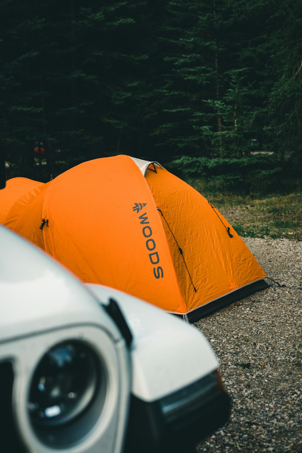 a couple of orange tents sitting next to a white car