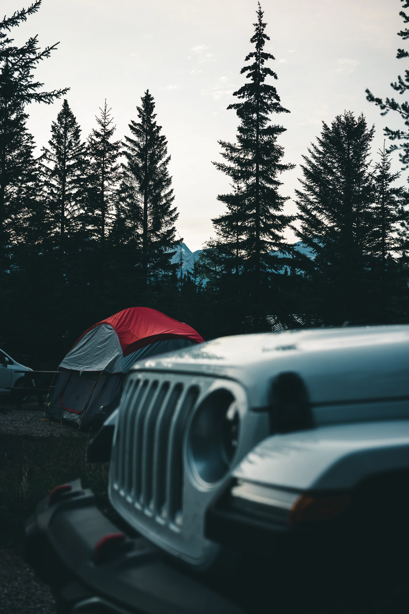 A campervan stands beneath mountains in the Canadian Rockies