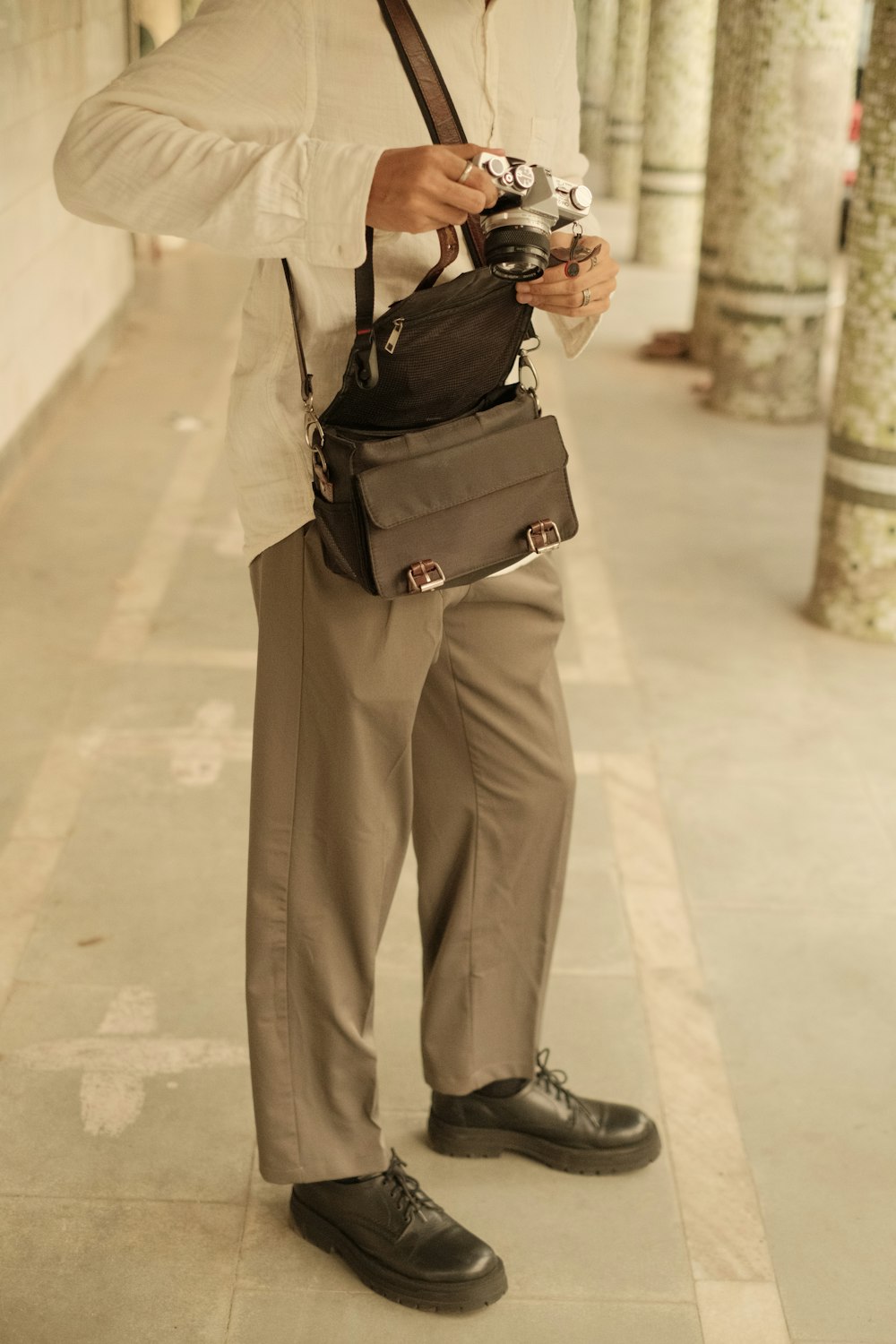 a man standing on a sidewalk holding a camera