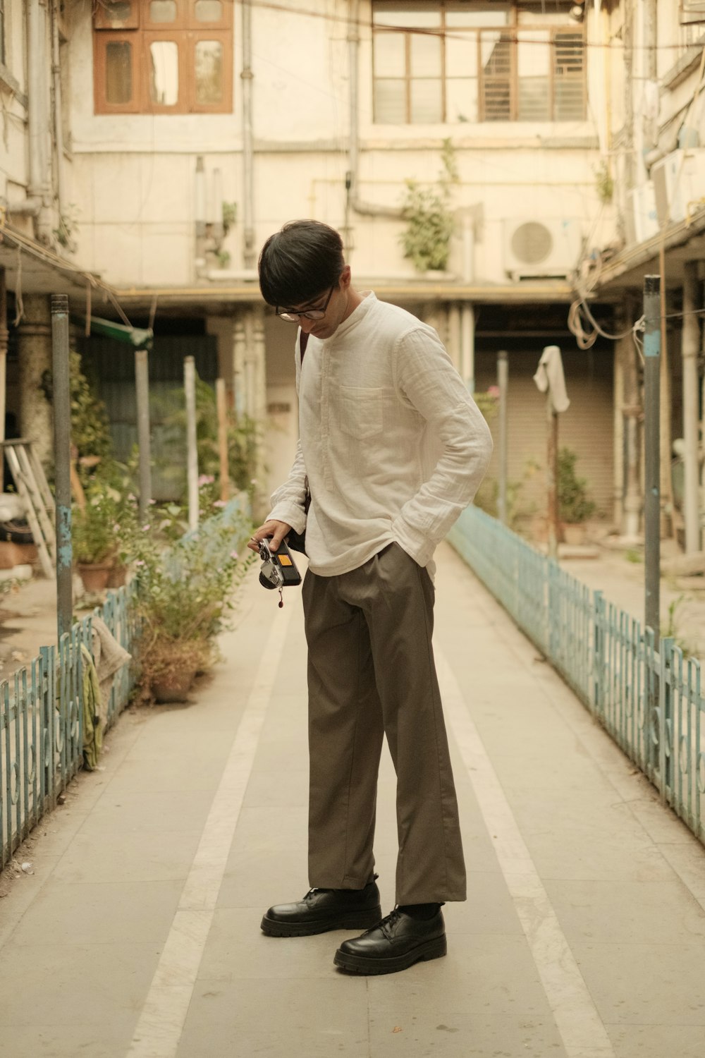 um homem parado em uma calçada segurando uma câmera