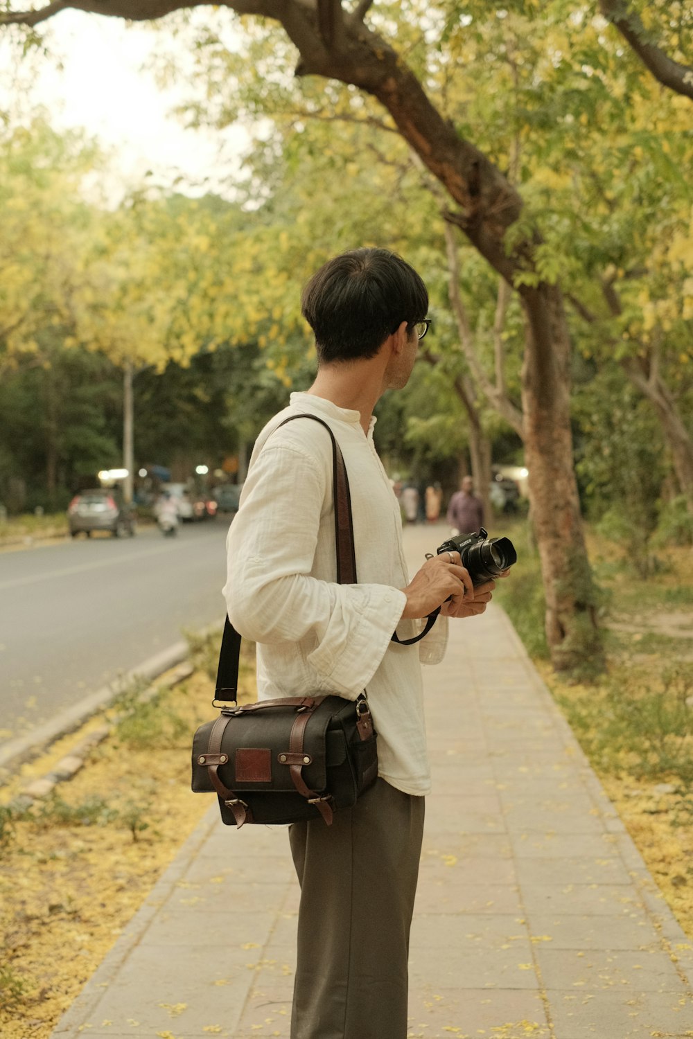 Ein Mann, der auf einem Bürgersteig steht und eine Kamera hält