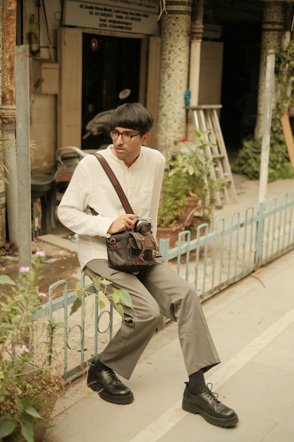 a man sitting on a fence with a camera