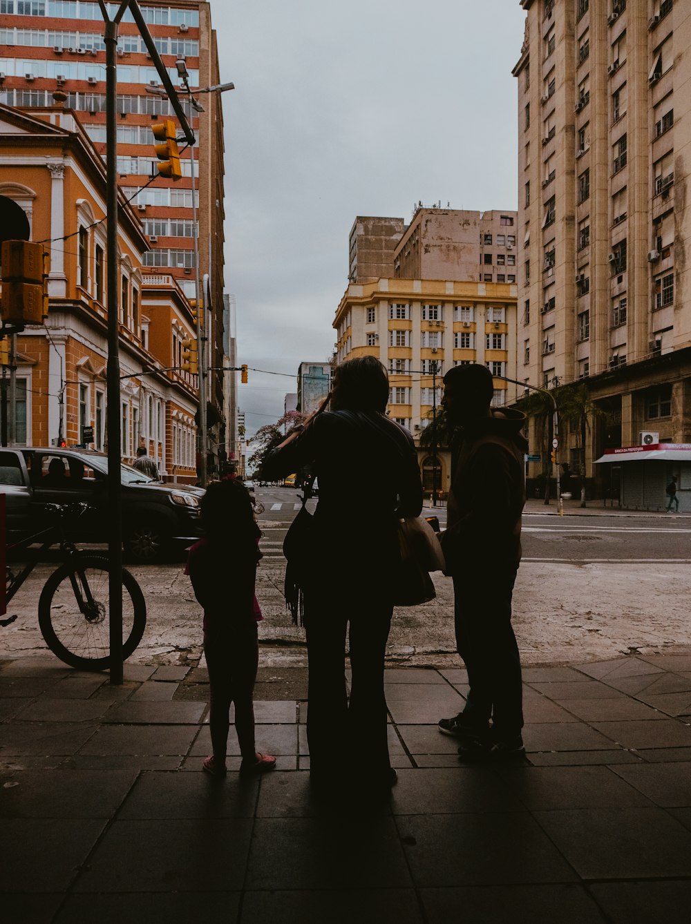 a group of people standing next to each other on a sidewalk