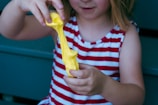 A joyful child playing with slime at a colorful, creative workspace.